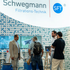 Vier Männer stehen am Messestand von Schwegmann Filtrations-Technik und unterhalten sich.