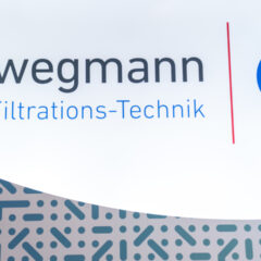Das Logo von Schwegmann Filtrations-Technik SFT auf weißem und gemustertem Hintergrund.